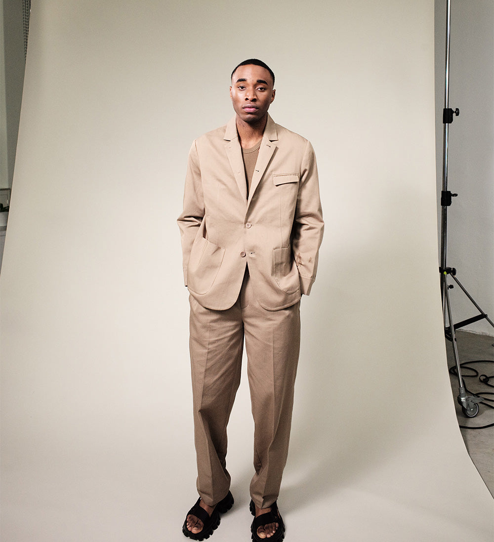picture of model in brown suit standing in studio
