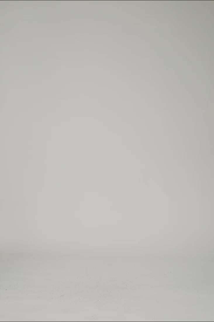 360 degree web shop video of male model wearing one t II oversized black organic cotton t shirt with sleeves over elbow before clean studio background 1c1y
