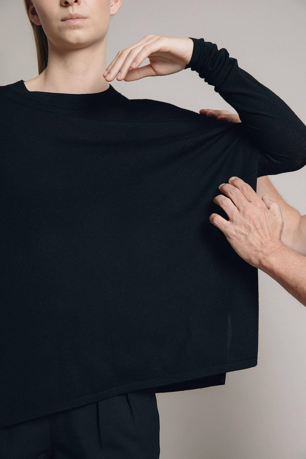 two male hands fixing ultrafine merino top with wide cut and slim sleeves female model moving her arm elegantly to her chin 1c1y